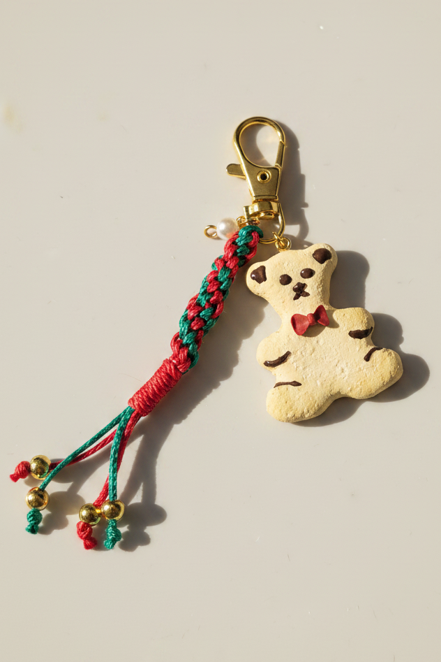 Teddy Bag Charm Weihnachtskeks – handgeformter Teddybär aus Clay mit Makramee-Band und goldfarbenem Karabiner